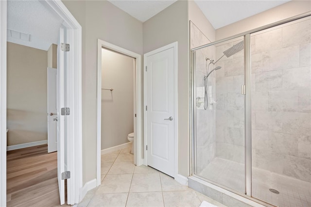 full bath with visible vents, baseboards, toilet, a stall shower, and tile patterned floors