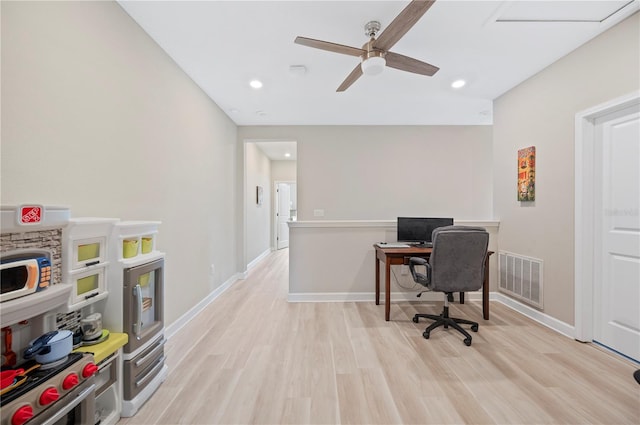 home office featuring light wood-type flooring, visible vents, baseboards, and a ceiling fan