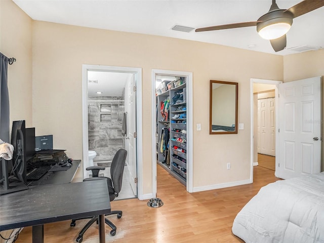 bedroom featuring visible vents, a walk in closet, baseboards, light wood-style floors, and a closet