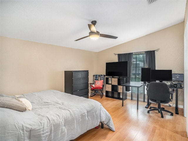 bedroom with vaulted ceiling, baseboards, light wood finished floors, and ceiling fan