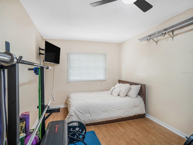 bedroom with ceiling fan, baseboards, and wood finished floors