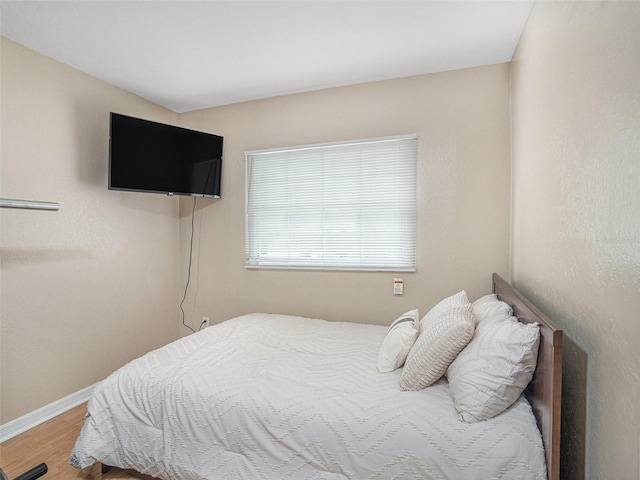 bedroom with wood finished floors and baseboards