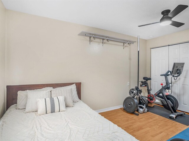 bedroom featuring a closet, a ceiling fan, baseboards, and wood finished floors