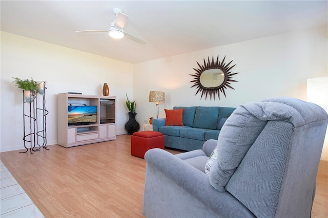 living room with ceiling fan, baseboards, and light wood-style flooring