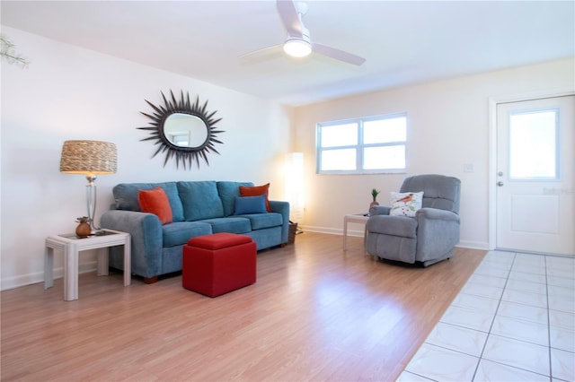 living area with a ceiling fan, plenty of natural light, baseboards, and light wood-type flooring