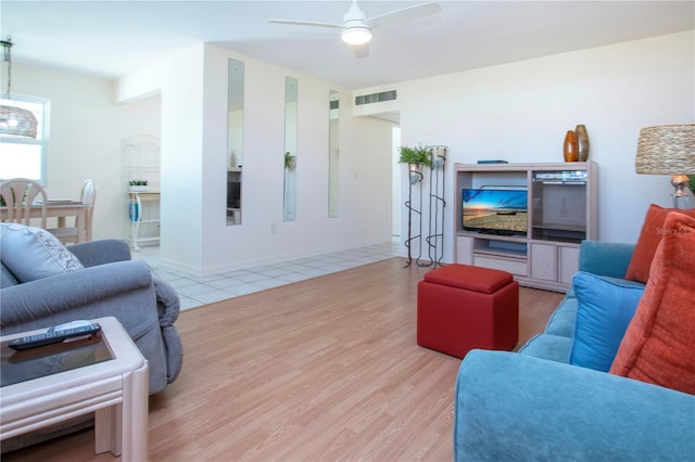 living room with visible vents, baseboards, ceiling fan, and wood finished floors