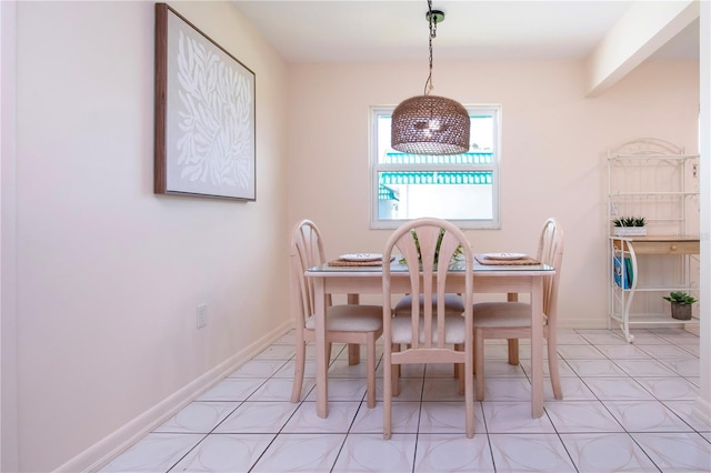 dining area featuring light tile patterned floors and baseboards