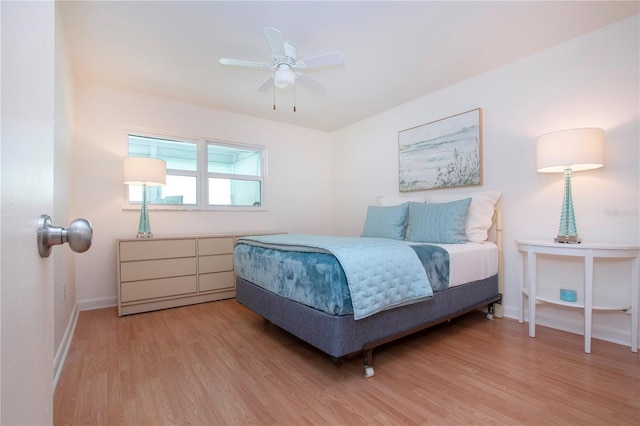 bedroom with ceiling fan, baseboards, and light wood-style floors