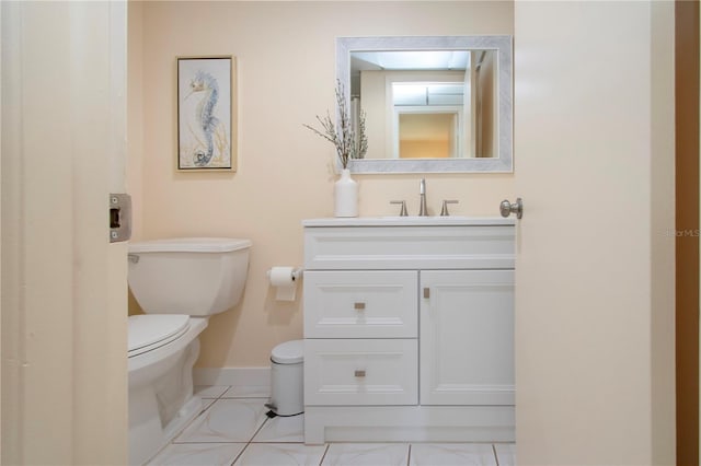 half bath featuring vanity, toilet, baseboards, and tile patterned flooring