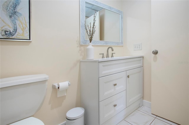 bathroom with vanity, toilet, and baseboards