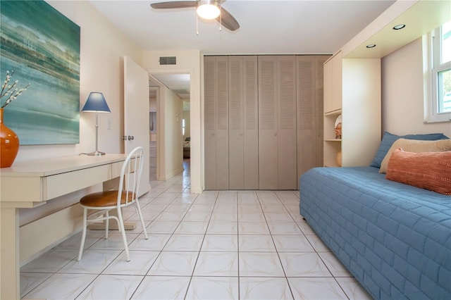 bedroom featuring light tile patterned floors, visible vents, a closet, and ceiling fan