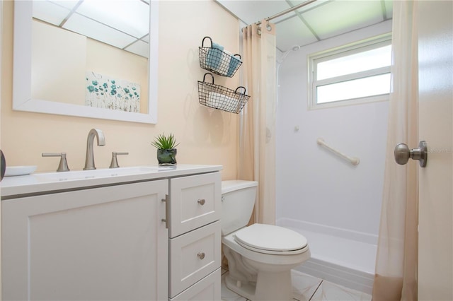 bathroom with vanity, a shower with shower curtain, toilet, and a drop ceiling