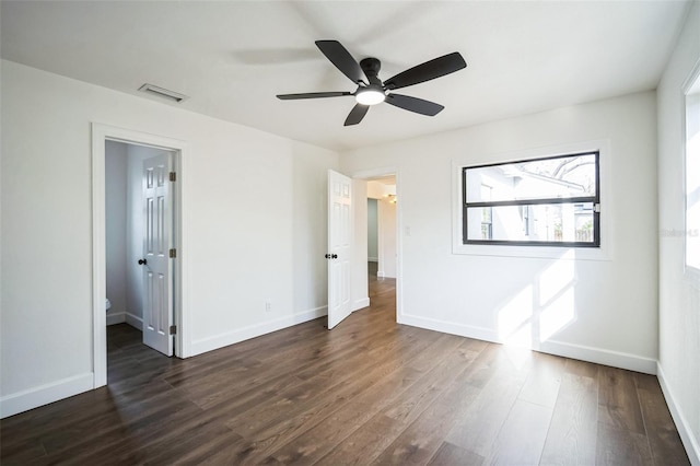 unfurnished bedroom featuring visible vents, baseboards, ceiling fan, and dark wood-style flooring