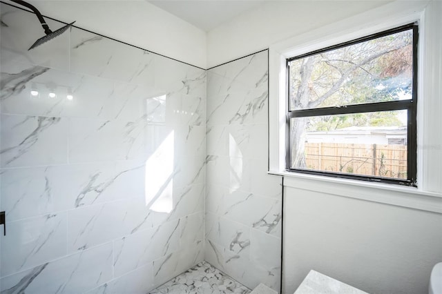 bathroom featuring a wealth of natural light and a marble finish shower