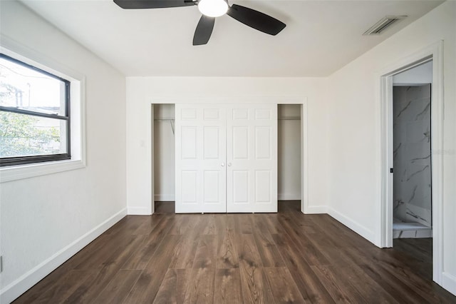 unfurnished bedroom with a closet, dark wood-style flooring, baseboards, and visible vents