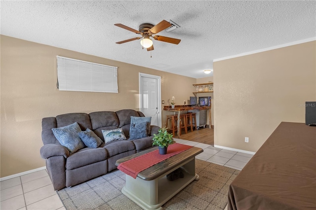 tiled living area with baseboards, a textured ceiling, and a ceiling fan