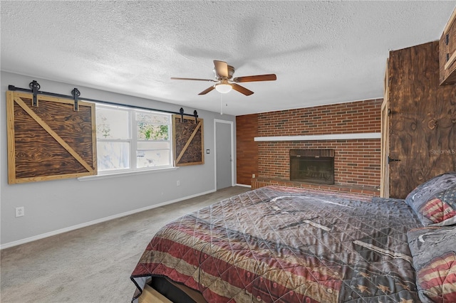 bedroom featuring a barn door, baseboards, carpet floors, and a textured ceiling