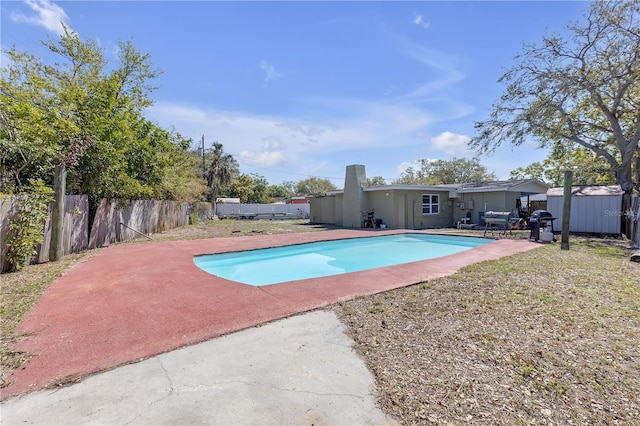 view of pool with a fenced in pool, a storage shed, a fenced backyard, an outbuilding, and a patio