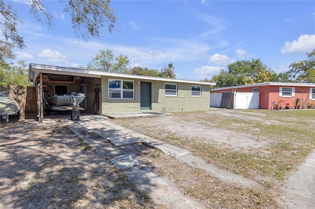 single story home with an attached carport, concrete driveway, and fence