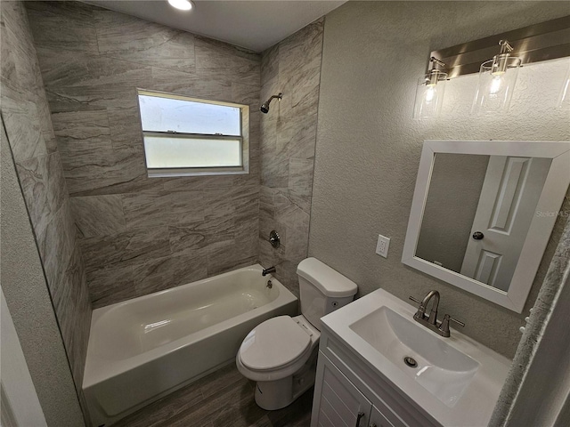 full bathroom featuring vanity, wood finished floors, shower / bath combination, toilet, and a textured wall