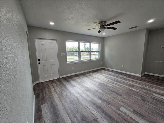 interior space featuring baseboards, wood finished floors, visible vents, and ceiling fan