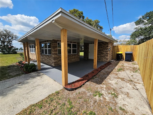 view of patio with an attached carport and fence