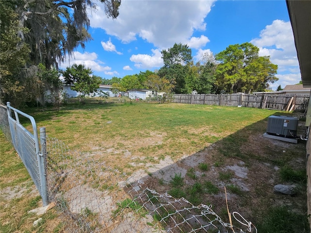 view of yard with cooling unit, a water view, and a fenced backyard