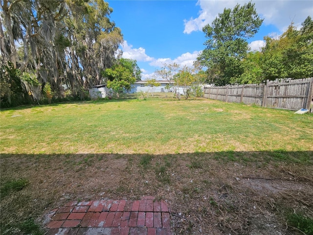 view of yard with a fenced backyard and a water view