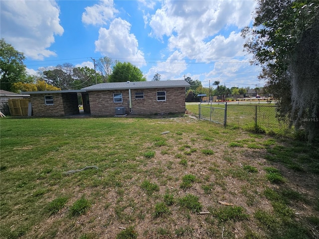 back of house with a yard, central AC, and fence