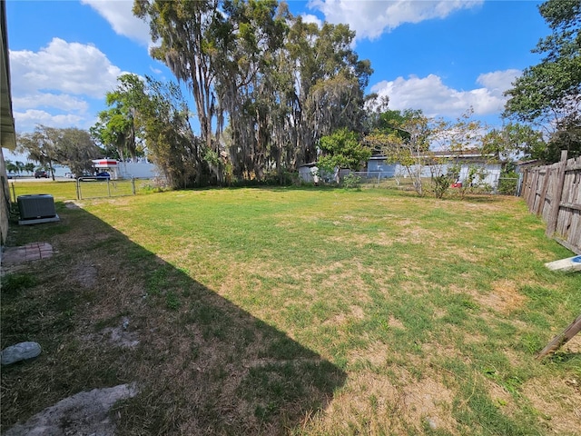 view of yard with central AC unit and a fenced backyard