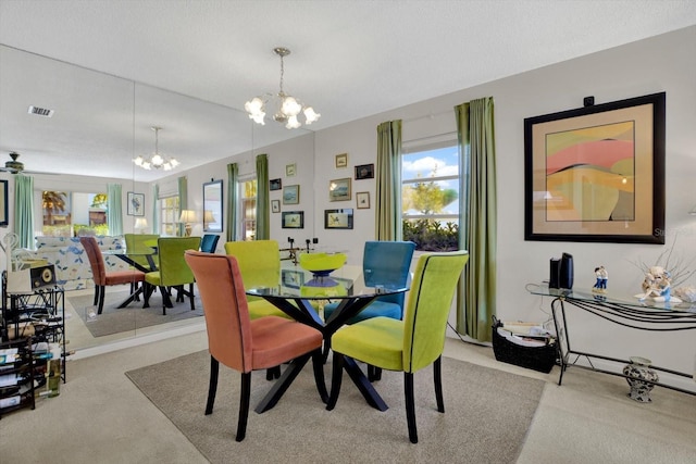 dining space featuring visible vents, a chandelier, and carpet flooring