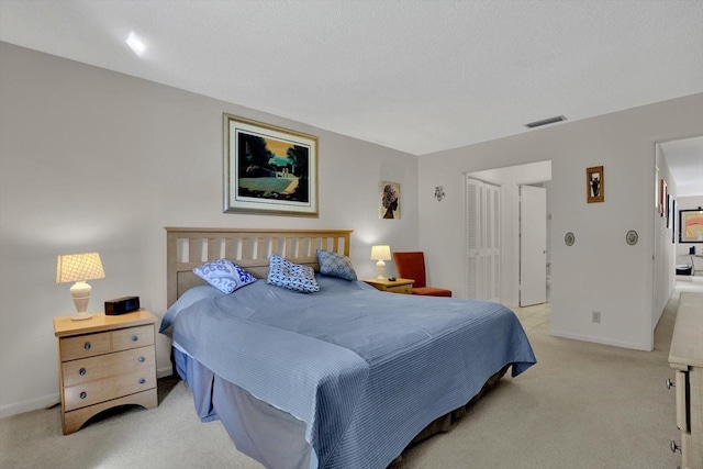 bedroom with light colored carpet, visible vents, a closet, and baseboards