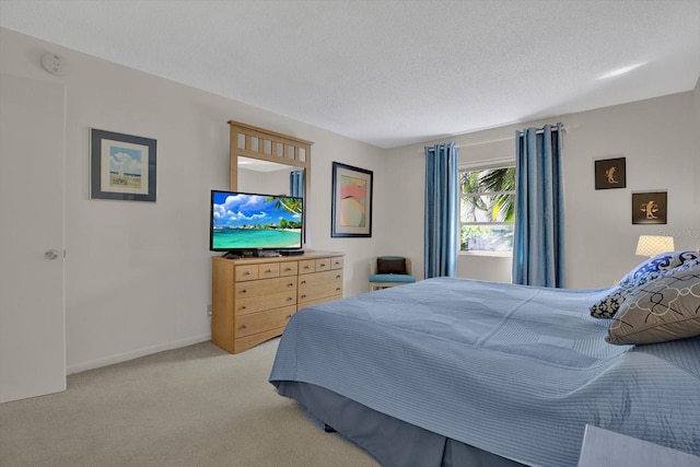 bedroom with light carpet, a textured ceiling, and baseboards