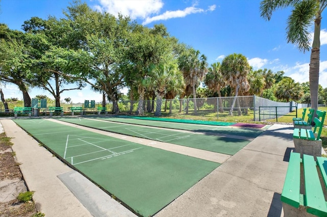 view of community with shuffleboard and fence