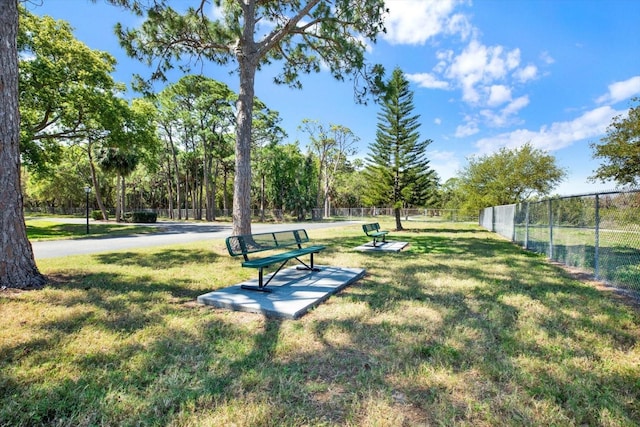 view of property's community with a yard and fence