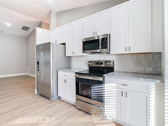 kitchen featuring light stone countertops, visible vents, backsplash, and stainless steel appliances