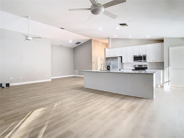 kitchen featuring stainless steel appliances, visible vents, ceiling fan, and vaulted ceiling