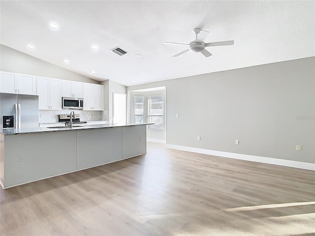 kitchen with visible vents, a sink, stainless steel appliances, white cabinets, and a large island with sink