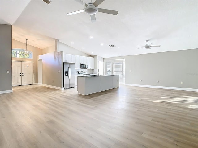 unfurnished living room with light wood-style flooring, a healthy amount of sunlight, visible vents, and ceiling fan