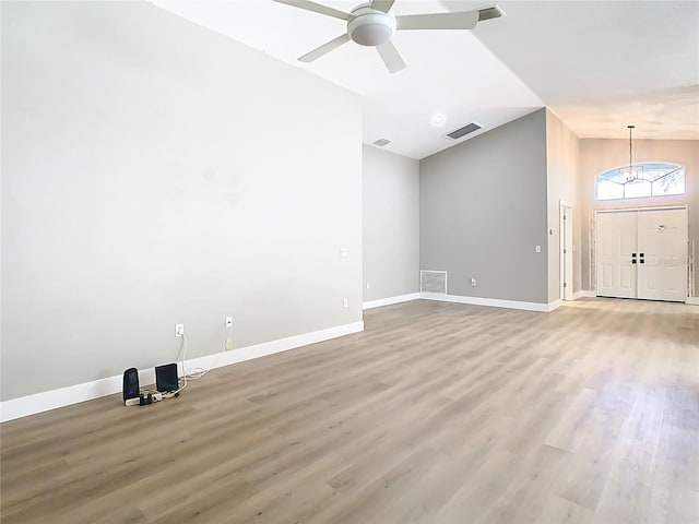 unfurnished room with lofted ceiling, wood finished floors, visible vents, and baseboards