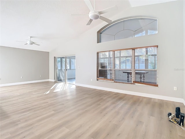 unfurnished living room featuring wood finished floors, a ceiling fan, and a wealth of natural light