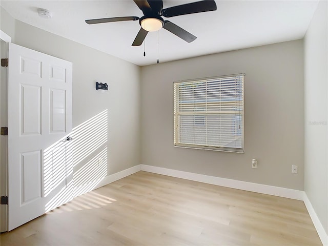 unfurnished room featuring light wood-type flooring, baseboards, and a ceiling fan