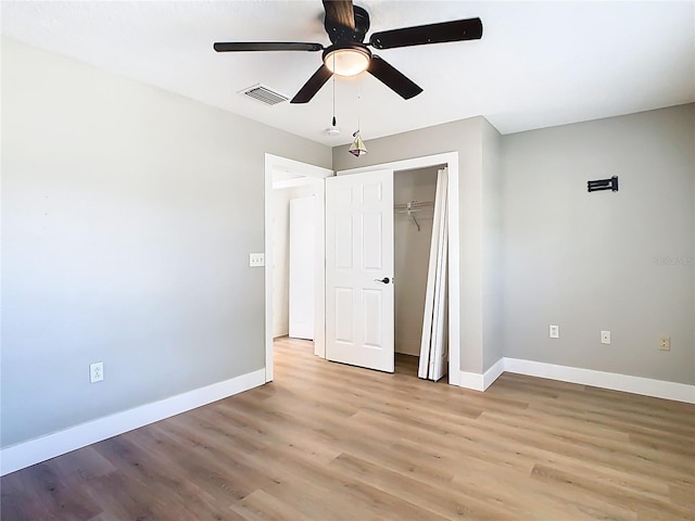 unfurnished bedroom with a closet, baseboards, visible vents, and light wood finished floors