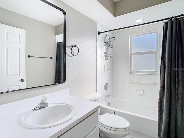 bathroom with shower / bathtub combination with curtain, toilet, vanity, and a textured wall