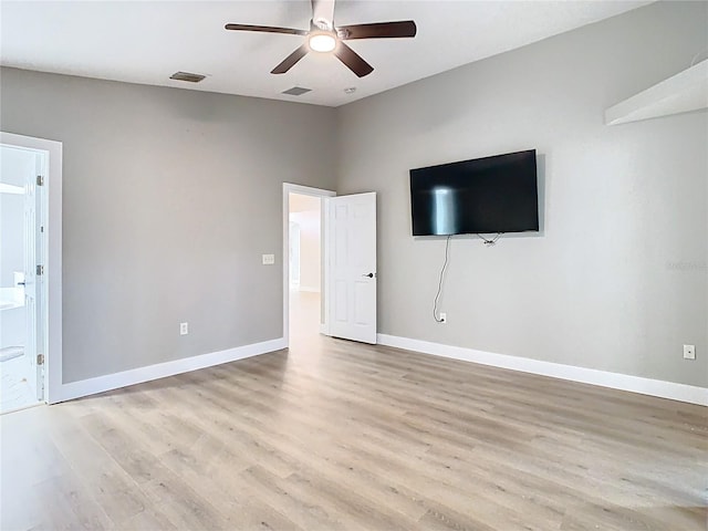 interior space with visible vents, light wood-style flooring, ensuite bath, and baseboards