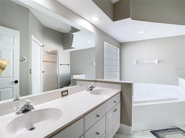 full bath with a garden tub, double vanity, tile patterned floors, and a sink