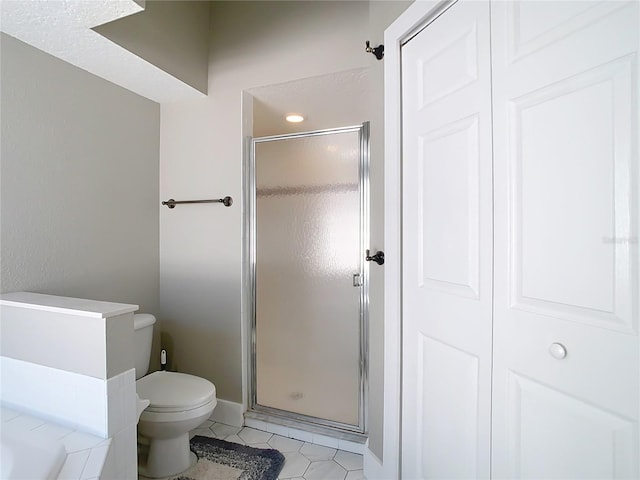 full bathroom with tile patterned floors, a shower stall, toilet, and baseboards