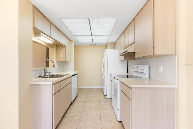 kitchen with white appliances, under cabinet range hood, light brown cabinetry, and a sink