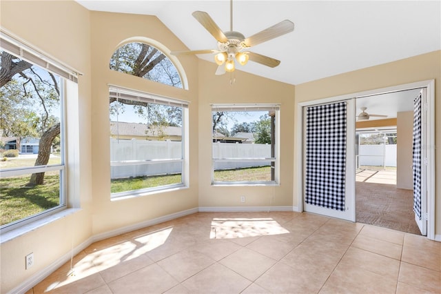 unfurnished sunroom featuring a healthy amount of sunlight, a ceiling fan, and vaulted ceiling