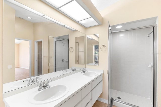 bathroom featuring a shower stall, double vanity, and a sink